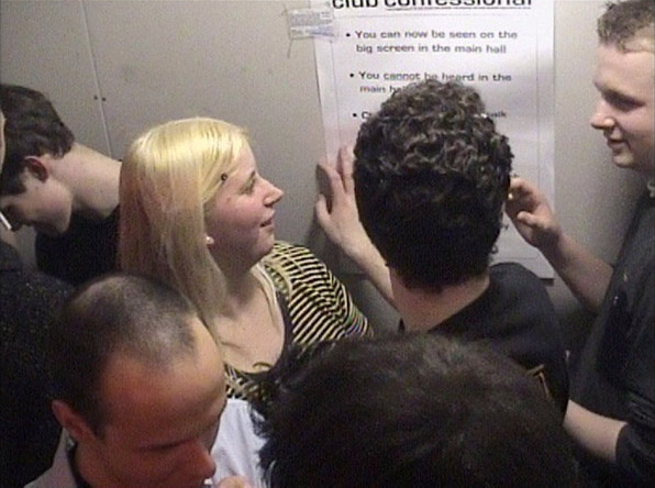 a crowd in the booth examine the instructions